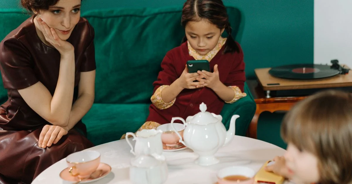 Une famille se retrouvant autour d'un thé, contrastant technologie et tradition.