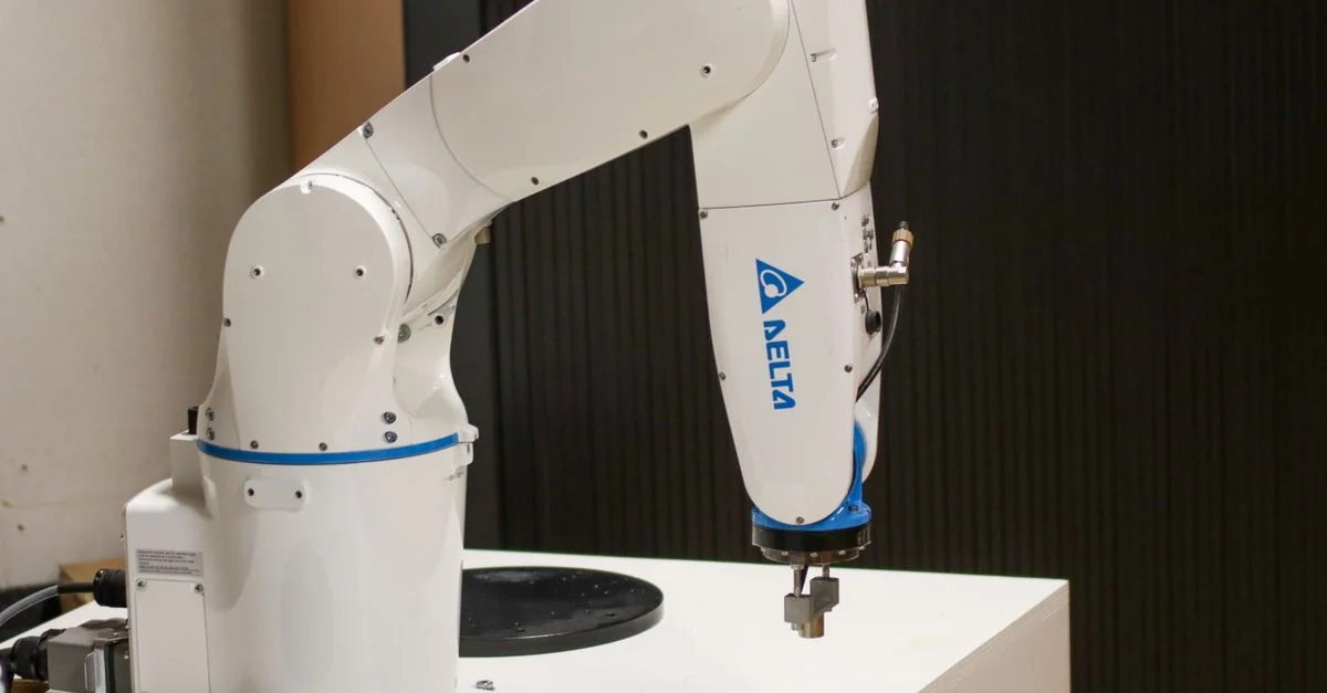 Gros plan d'un bras robotique de marque Delta dans un environnement industriel, mettant en avant la technologie d'automatisation.